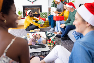 Diverse group of friends having christmas video call with african american couple