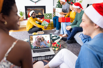 Diverse group of friends having christmas video call with african american couple