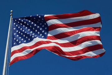 Fototapeta premium large american flag with stars and stripes waving proudly on a metal flagpole against a clear blue sky
