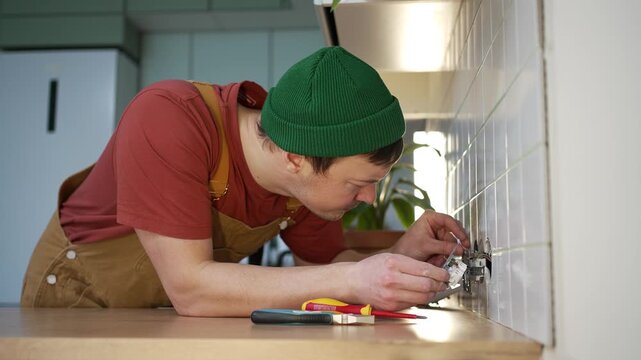 Unsafe work practices leading to a severe electric shock for an electrician installing a wall socket, illustrating the dangers of handling live wires without proper precautions