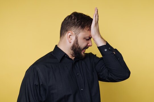 Man experiencing frustration and disappointment against a vibrant yellow background during a moment of realization