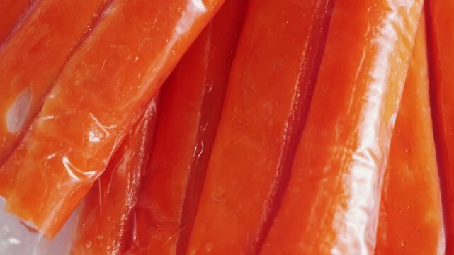 Crab sticks on a plate in packaging, rotating salad ingredient. High quality 4k footage