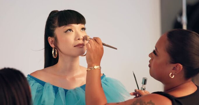 Model, makeover and women with makeup, backstage and photoshoot preparation, talk or beauty process. Behind the scenes, people and foundation application with tools, creative and production setup