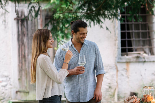 Couple with wine glasses having a romantic candelight meal next to a cottage