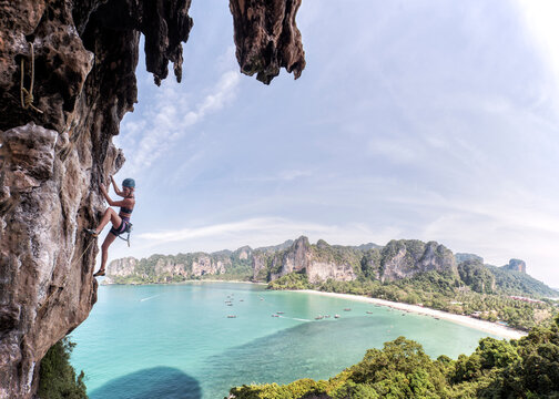 Thailand, Krabi, Thaiwand wall, woman climbing in rock wall above the sea