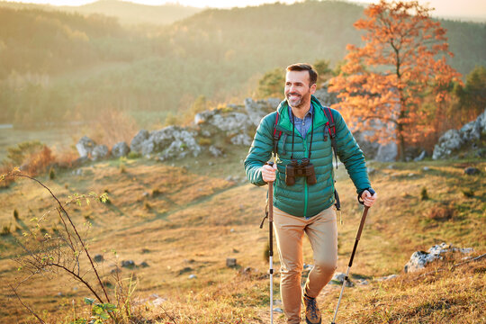 Happy man walking on trail on a hiking trip in the mountains
