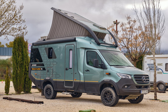 A Hymer Venture S off-road camper van with a pop-up roof and solar panels is parked in Ronda Andalucia Spain showcasing a modern vehicle for adventure travel and an outdoor lifestyle. This recreationa