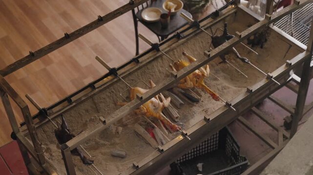Traditional open-fire roasting setup in Cat Cat Village, Sapa Vietnam, showing local cooking culture with whole poultry grilled over charcoal in an authentic ethnic mountain setting.