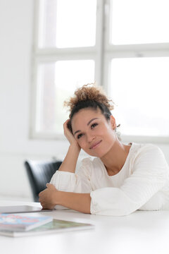 Portrait of smiling young woman sitting at table