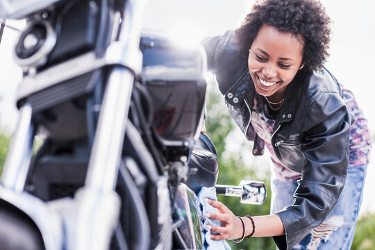 Young woman cleaning her motorcycle