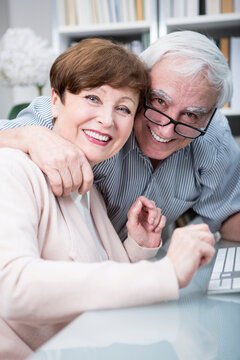 Senior couple embracing and smiling at camera