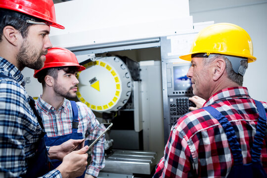 Staff in factory at CNC machine