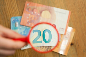 Euro banknotes under a magnifying glass. The concept of inflation, poverty, economic crisis. The concept of saving money. Finance, business, investment. Saving savings at home. 