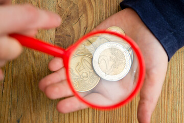 Euro banknotes under a magnifying glass. The concept of inflation, poverty, economic crisis. The concept of saving money. Finance, business, investment. Saving savings at home. 
