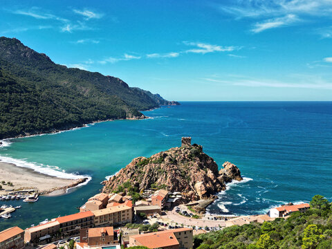 Bay of the town of Ota and port with ships on the island of Corsica in late summer