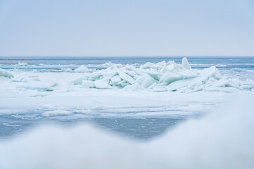 Stacked Ice Floes on the Baltic Sea with Blurry Ice in Foreground and Endless Blue Ice in Background © Jens