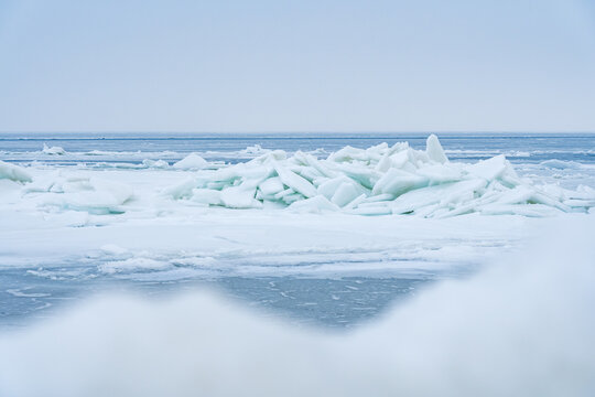 Stacked Ice Floes on the Baltic Sea with Blurry Ice in Foreground and Endless Blue Ice in Background