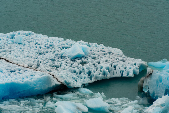 View of turquoise icebergs with intricate textures float serenely on the glacial waters, a frozen landscape of stark beauty, El Calafate, Santa Cruz Province, Argentina.
