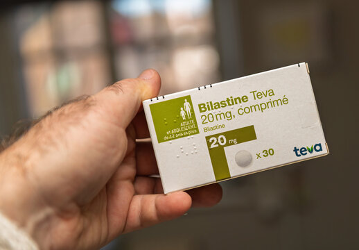 Munich, Germany - Jan 16, 2026: Close-up of a hand holding a Bilastine Teva 20mg antihistamine medicine box for adults and adolescents aged 12 and older, photographed indoors with soft natural light.