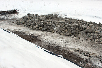Polluted riverbank during winter cleanup &mdash; ideal for environmental remediation, contamination removal and municipal ecological intervention