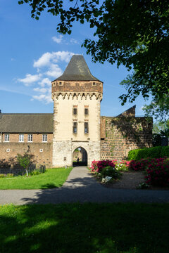 Historic Gate Tower of Friedestrom Castle in the Medieval Fortress Town of Zons Germany with Summer Garden and Blue Sky