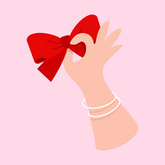 Feminine Hand Holding a Festive Red Bow for Mother's Day