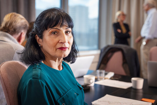 Portrait of confident senior businesswoman sitting in office meeting room
