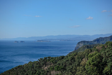 Obraz premium Cliffside forest and Pacific Ocean islands viewed from Shikoku Henro coastal route Japan