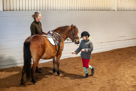 Mother and daughter with horse in stable