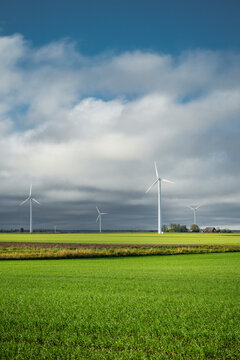 View of wind turbines in field against sky