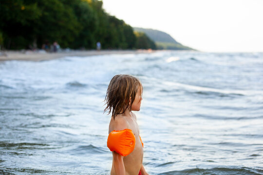 Shirtless girl with looking away while standing in sea