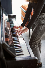 Woman playing upright piano in casual indoor setting © TRAVELARIUM