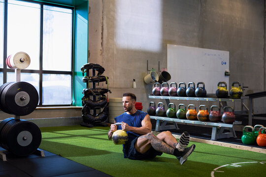 Full length of athlete doing weight training with kettle bell
