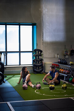 Coach instructing woman while working out in gym