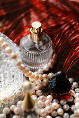 Luxury feminine still life: dark red perfume bottle, gold atomizer, crystal glass , Soft warm lighting, romantic reflections, elegant glamour for beauty, fragrance, and high-end lifestyle concepts.