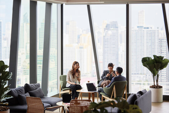 Group of male and female entrepreneurs planning strategies while sitting in modern office