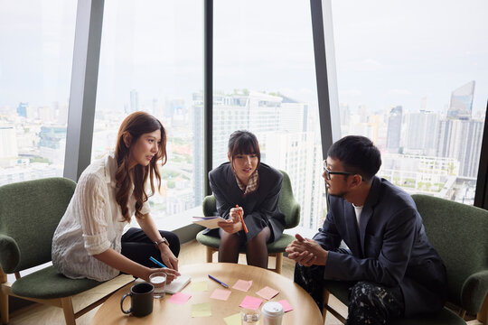 Group of male and female entrepreneurs discussing ideas while sitting around table at home