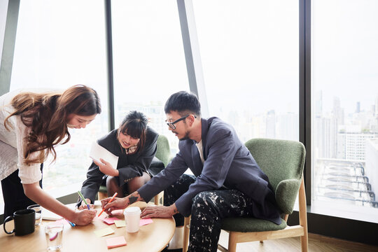 Group of male manager assisting female employees while planning strategies in meeting