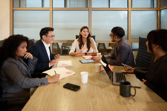 Smiling businesswoman discussing marketing strategies with colleagues at office