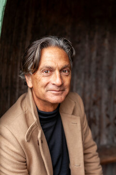 Portrait of smiling senior man in trench coat