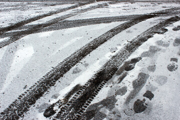 Tire tracks and human footprints on snowy or muddy ground &mdash; ideal for forensic, environmental or transportation documentation.