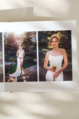 page of an open photo book with wedding photos on a white table