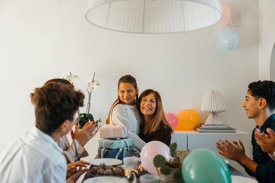 Family clapping for girl while celebrating birthday at home