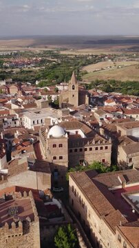 Vertical aerial moving forward toward the medieval Palacio de Moctezuma in C&aacute;ceres, Spain, revealing historic architecture within the UNESCO Old Town.