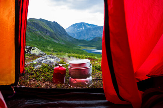 Camping stove outside tent with mountains in background