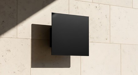 Minimalist Black Square Object Casting Shadow on Textured Wall.