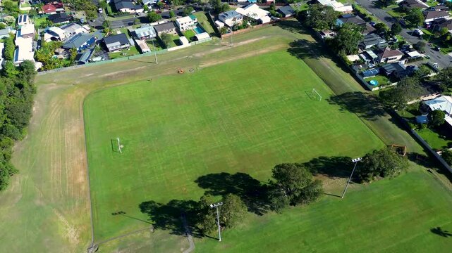 Drone aerial landscape of grassy public soccer and football oval fields at local public park meadow surrounded by residential suburban housing on Killarney Vale Central Coast Australia sports tourism