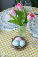 Easter table setting with fresh tulips flowers. Festive dinner.