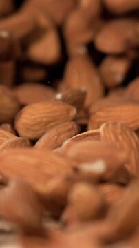 Slow Motion, Intricately Crafted Visual Capturing Almonds Flowing Out Of Sack Illuminated By Gentle Warm