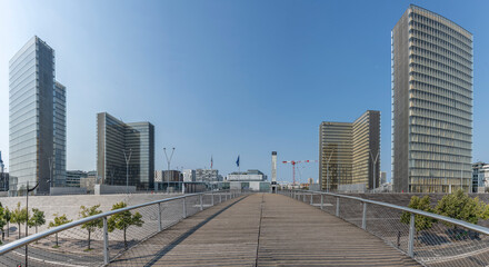 Obraz premium Paris, France - 08 15 2025: La Seine River. Panoramic view of the Simone de Beauvoir footbridge and the towers of the François-Mitterrand Library background